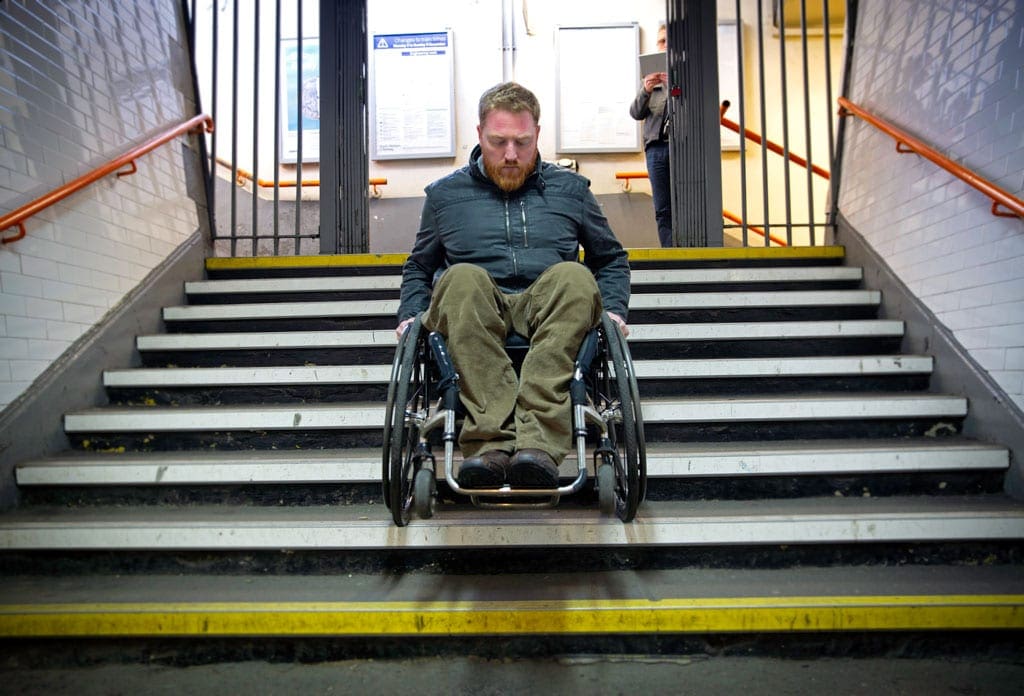 Pete Donnelly going down steps at Queenstown Road (Battersea) station which is inaccessible