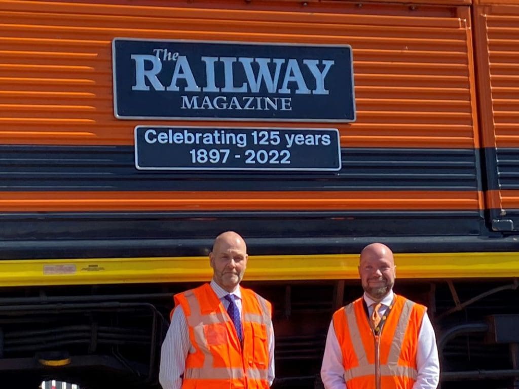 Two men in front of the loco with the nameplates "The Railway Magazine" and "Celebrating 125 years 1897-2022."